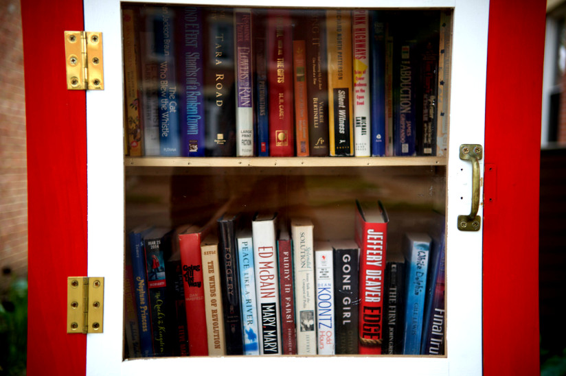 Close-up photo of books behind a glass door with a handle