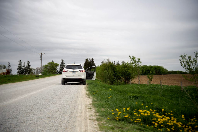 Photo of an abandoned white car with passenger side door open