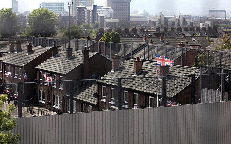 Photo of the Protestant Cluan Place in East Belfast which is divided by a massive wall and fence that separates the Protestant Cluan Place from the Catholic Short Strand area